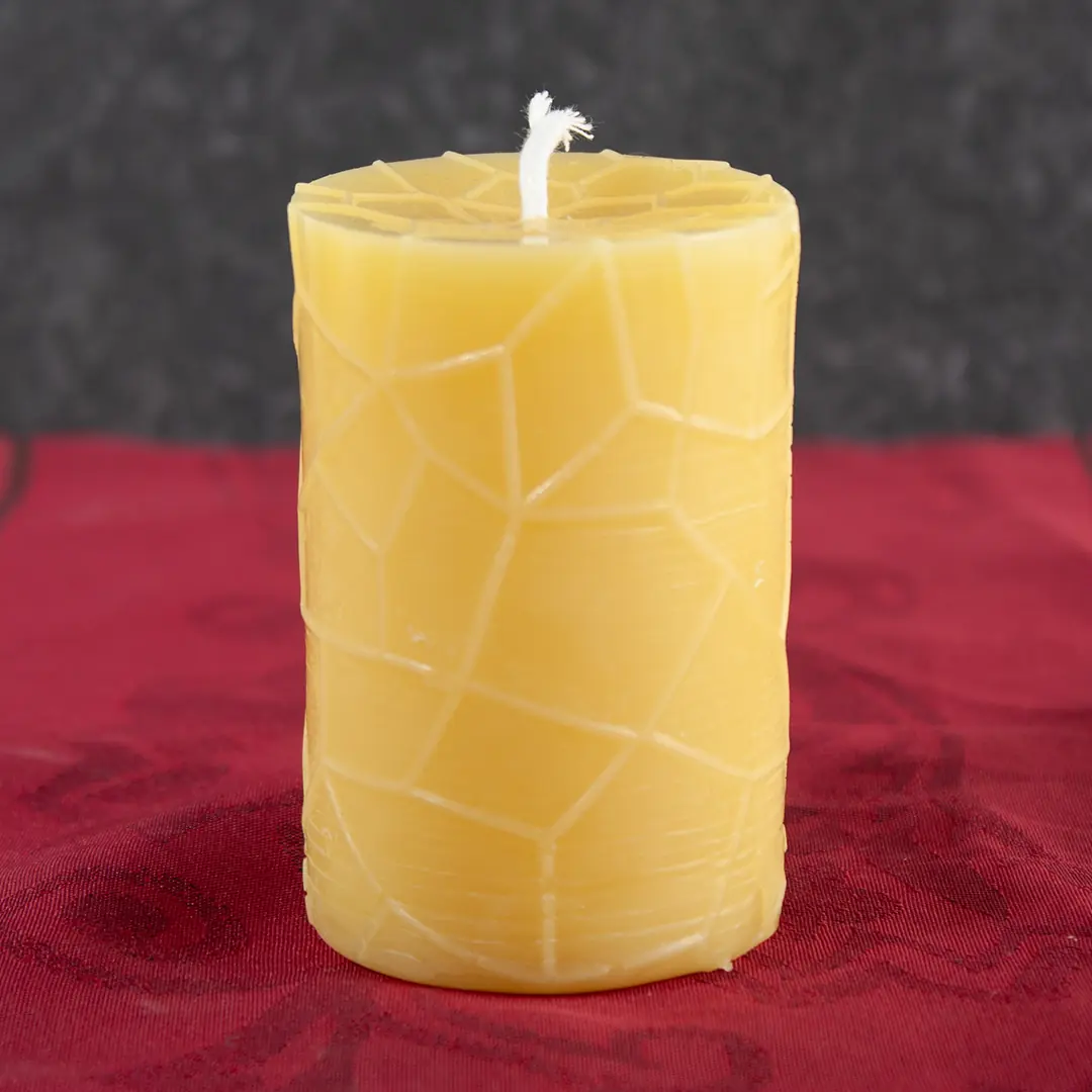 Goldgelbe Bienenwachs-Stumpfkerze mit geometrischem Facettenrelief, 5cm Durchmesser und 7,5cm Höhe