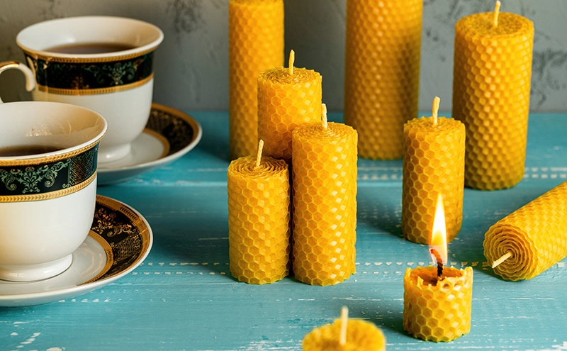 Goldgelbe Bienenwachskerze mit sichtbarer Wabenstruktur und sanfter Flamme im Fokus