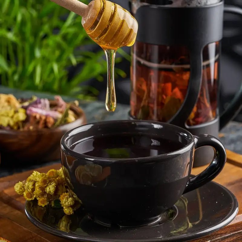 Flüssiger Honig von der Imkerei Genzel wird in warmen Tee eingerührt