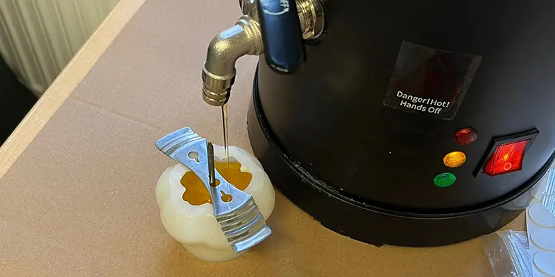 Natürliches goldgelbes Bienenwachs fließt in Kerzenform beim Event