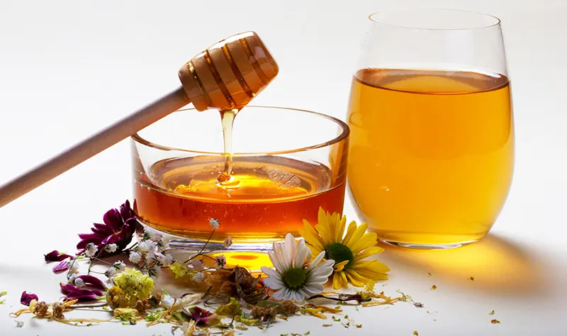 Honigdipper mit Honig zeigt richtige Portionsgröße