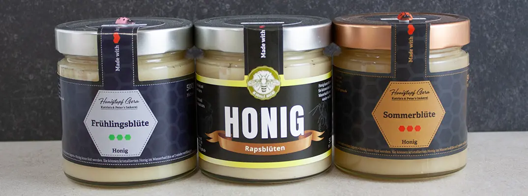 Unterschiedliche Honigsorten nebeneinander zeigen Farbspektrum von hell bis dunkel