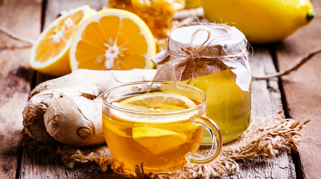 Heißer Tee mit Honig, Zitronenscheiben und Ingwer gegen Erkältungssymptome