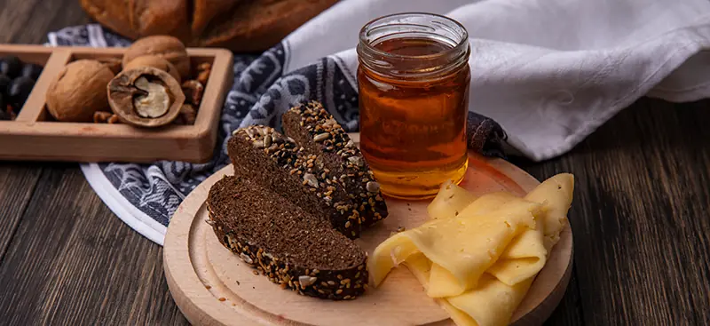 Sommerblütenhonig auf Vollkornbrot mit kräftigem Käse als Verwendungsbeispiel